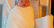 Jaxson is registered to the contest to win money with this photo: newborn, baby, swaddled, hat, sleeping, hospital, bassinet, blanket, infant, bed, soft, peaceful, portrait, person, indoor, resting, cute, newborn_baby, healthcare, comfort