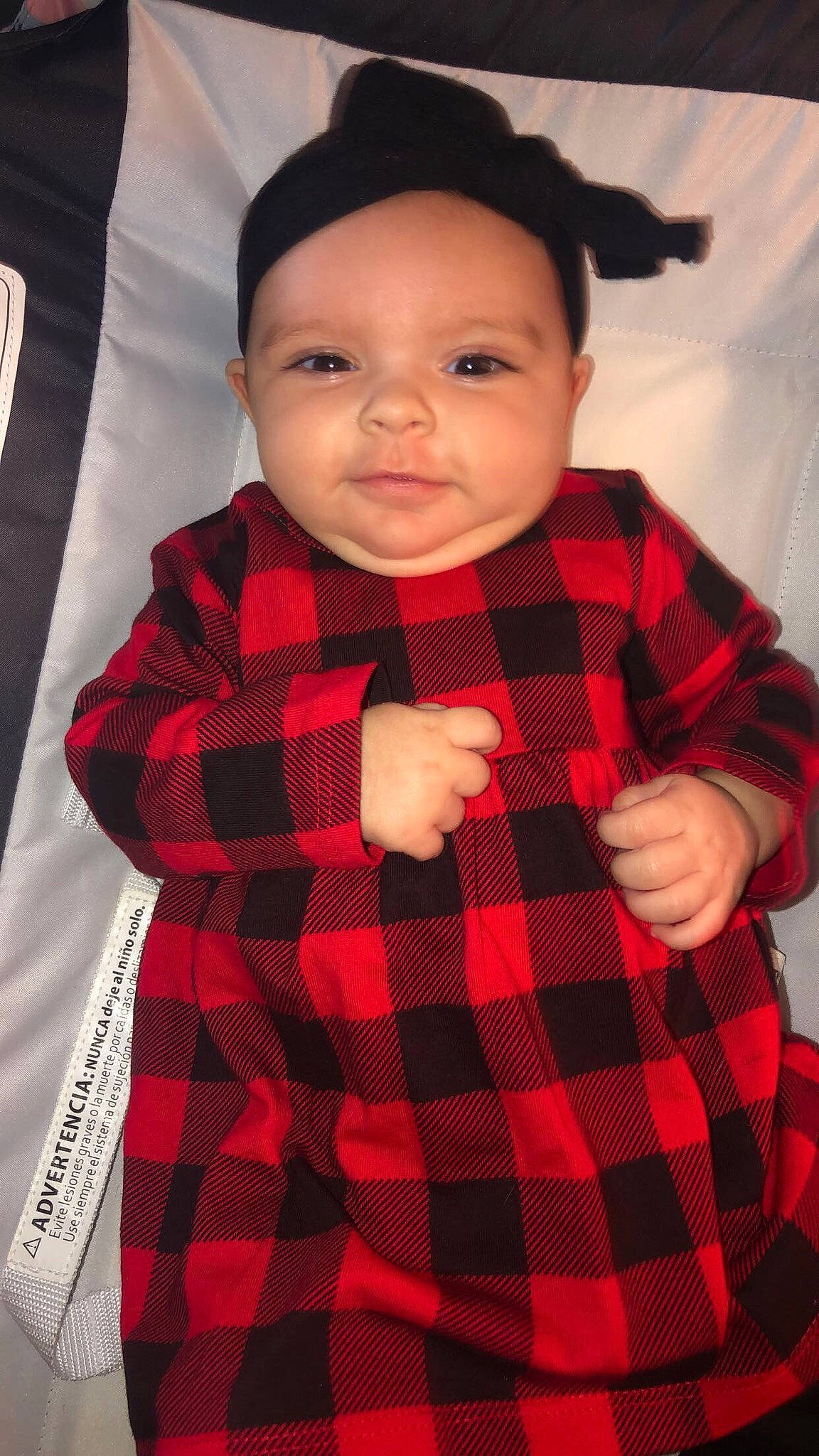 Alaynah is registered to the contest to win money with this photo: arm, baby_toddler_clothing, black, collar, dress, eye, face, fashion, finger, gesture, hand, headwear, lip, neck, outerwear, person, plaid, skin, sleeve, standing