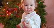 Amarra is registered to the contest to win money with this photo: accessories, baby, christmas, christmasdecorations, clothing, conifer, face, festival, fir, happy, head, lighting, person, photography, plant, portrait, pottedplant, smile, t_shirt, tree