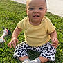 baby, child, cute, daylight, grass, greenery, happy, infant, outdoor, playful, polka_dot_pants, sidewalk, sitting, smiling, socks, sunlight, toy, vehicle, wheel, yellow_shirt