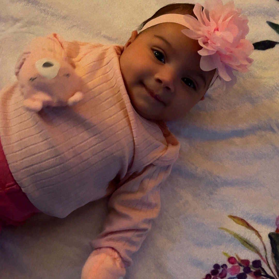 Aurora is registered to the contest to win money with this photo: animal, baby, bonnet, cap, clothing, face, flower, flowerarrangement, flowerbouquet, footwear, hat, head, newborn, person, petal, photography, plant, portrait, rose, shoe