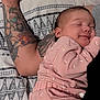 Athena is registered to the contest to win money with this photo: baby, sleeping, pink_outfit, tattoo, arm, blanket, pattern, cozy, resting, closeup, infant, human, skin, bed, comfort, cute, peaceful, relaxation, person, sleep