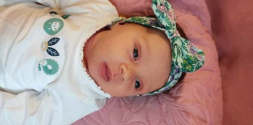 Ana participe au concours pour gagner de l'argent avec cette photo : baby, baby_toddler_clothing, cheek, child, chin, close_up, eye, eyebrow, eyelash, face, happy, head, headgear, headwear, iris, lip, neck, nose, person, pink