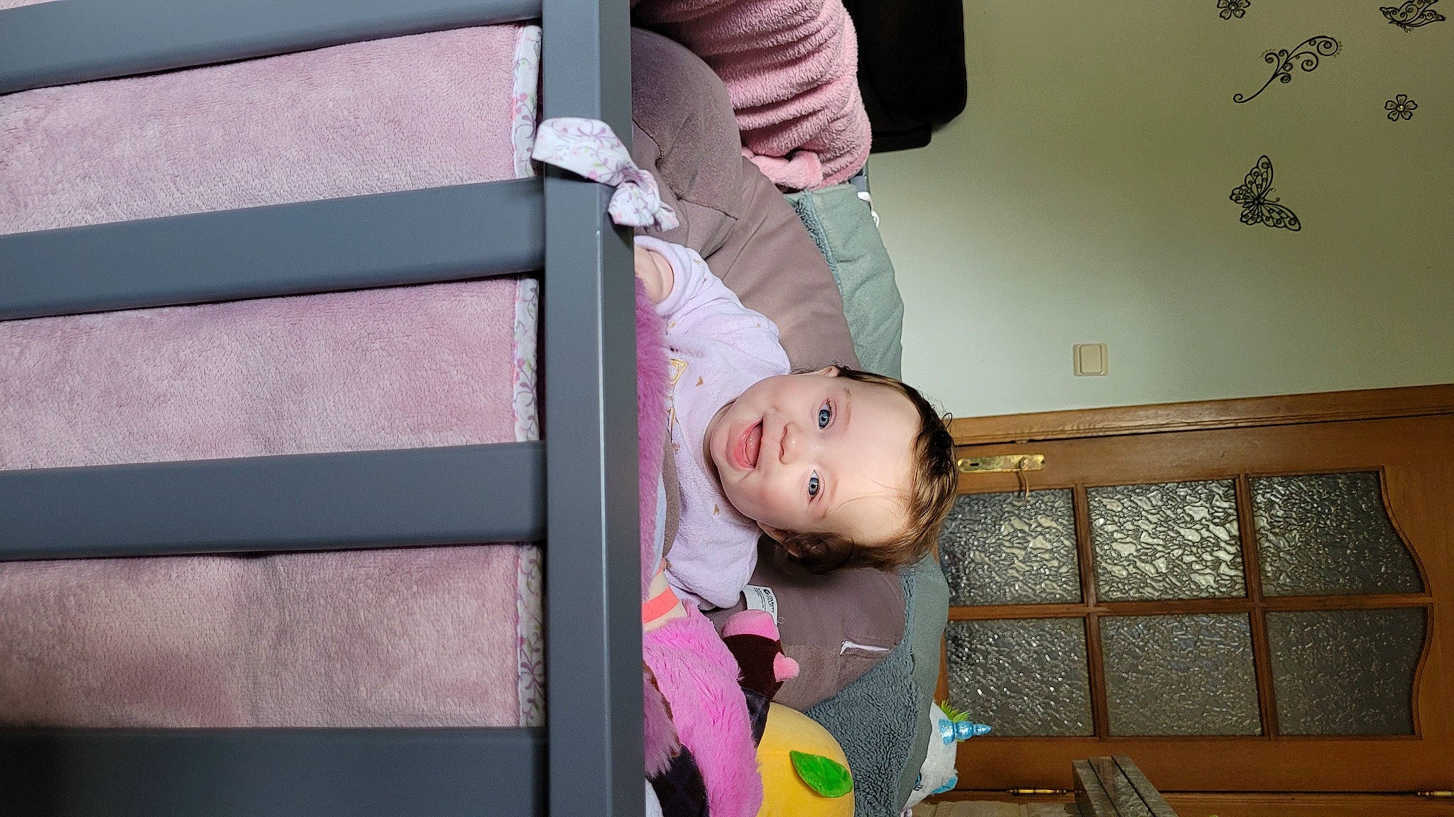 Ana participe au concours pour gagner de l'argent avec cette photo : baby, baby_products, baby_safety, baby_toddler_clothing, child, comfort, flooring, fun, happy, magenta, person, pink, play, purple, room, sitting, toddler, tree, wood