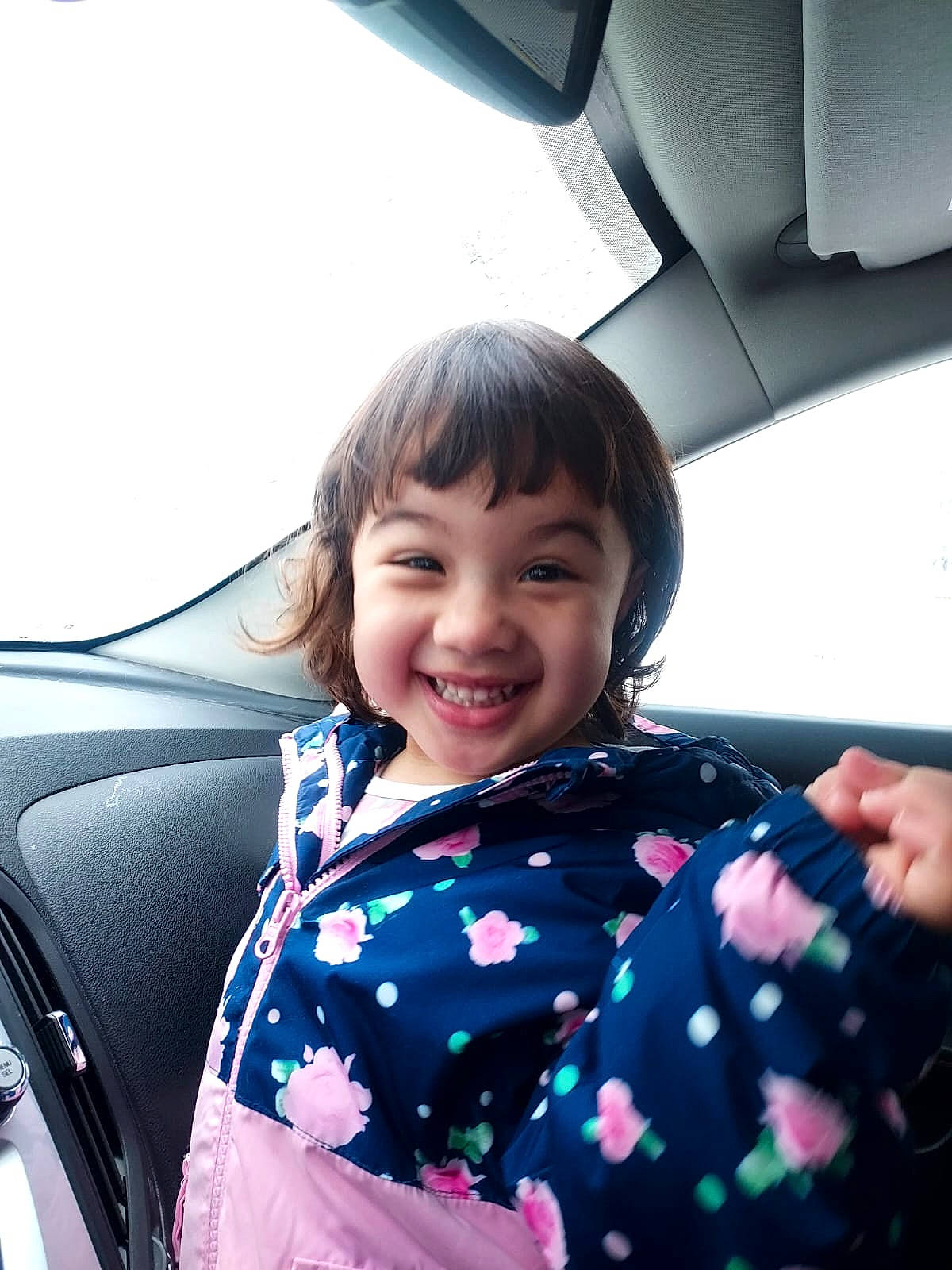 Amelia is registered to the contest to win money with this photo: auto_part, automotive_design, automotive_exterior, beauty, black_hair, car, car_seat, comfort, face, fun, happy, joy, leisure, motor_vehicle, person, smile, steering_wheel, toddler, travel, vehicle_door