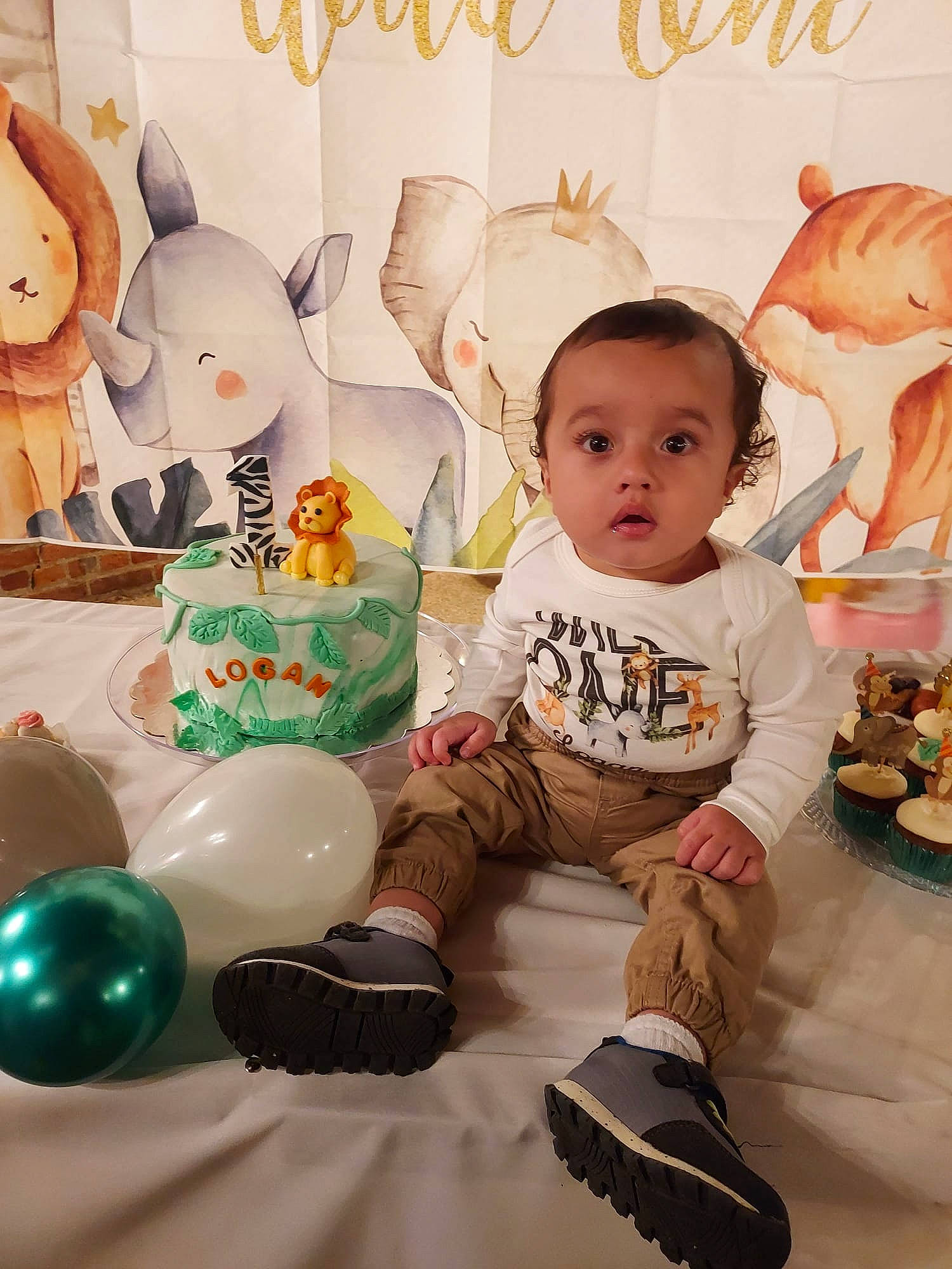 Logan is registered to the contest to win money with this photo: baby, baby_toddler_clothing, balloon, child, event, facial_expression, flooring, fun, happy, head, mammal, person, pink, product, room, sitting, sock, stuffed_toy, toddler, toy