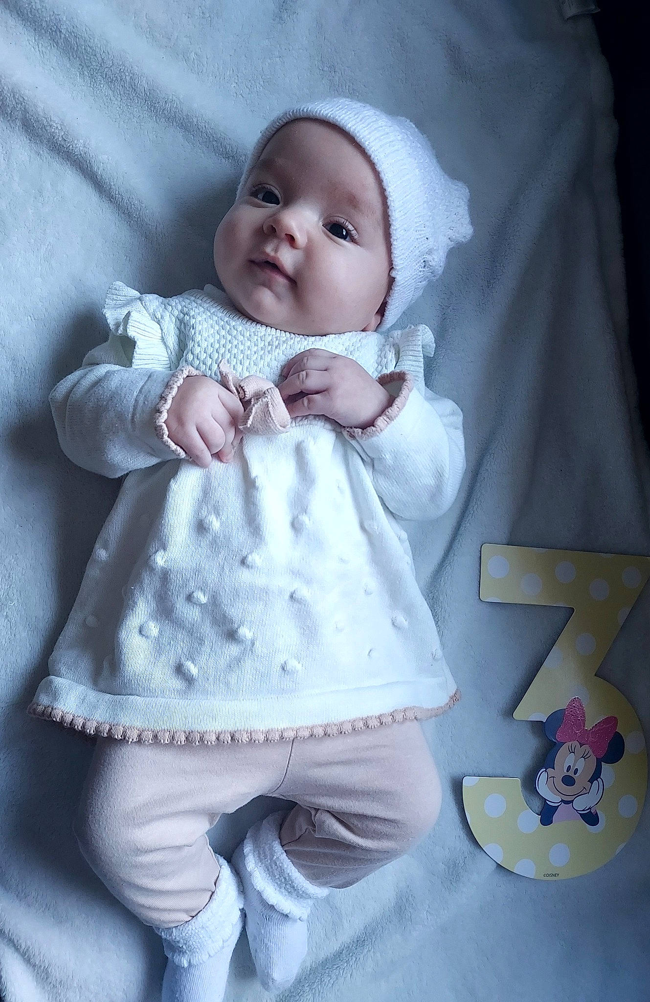 Mila is registered to the contest to win money with this photo: arm, baby, baby_toddler_clothing, cheek, collar, comfort, finger, hand, happy, headgear, headwear, human_body, iris, pattern, person, product, purple, skin, sleeve, smile