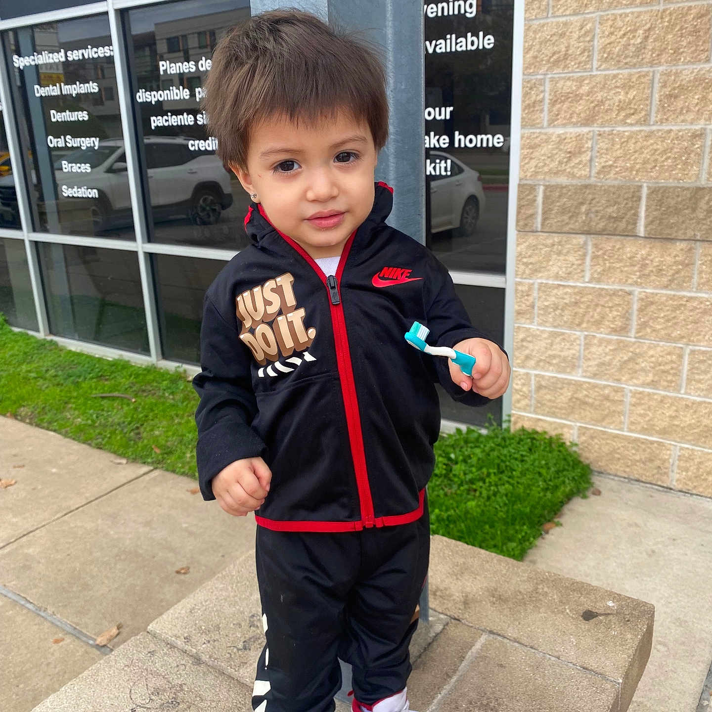 Messiah joined the competition — help win amazing prizes! boy, brick_wall, building, casual_clothing, child, concrete, curious, daytime, grass, nike, outdoor, person, sidewalk, sneakers, standing, toothbrush, tracksuit, urban, window, young_child