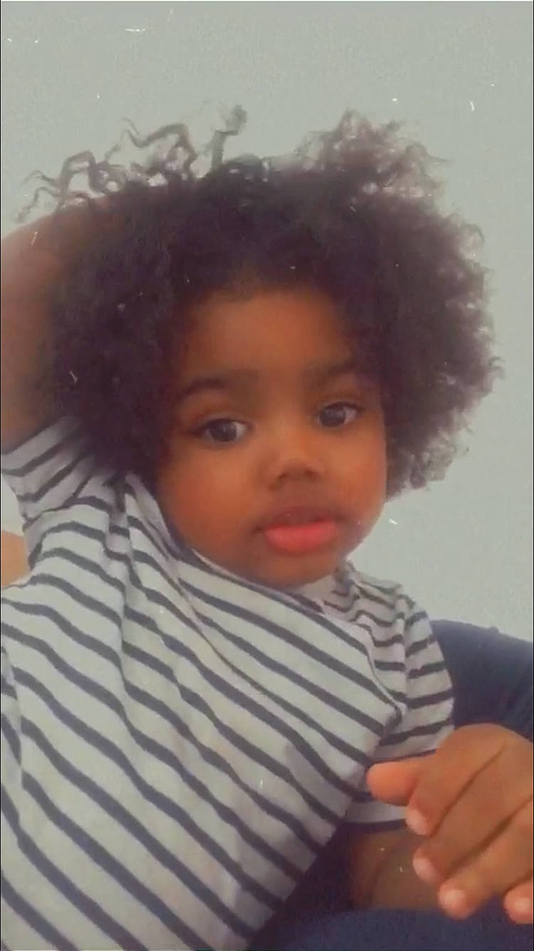Shiloh is registered to the contest to win money with this photo: afro, baby, black_hair, cheek, child, cool, eyebrow, eyelash, fashion_accessory, forehead, gesture, hair, happy, jheri_curl, lip, nail, nose, person, skin, thumb