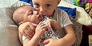 Leigha is registered to the contest to win money with this photo: baby, child, sibling, cuddle, love, family, indoor, blanket, pillow, comfort, toddler, clothing, cute, affection, skin, hand, face, hair, holding, expression