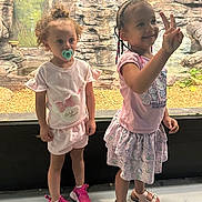 Leigha joined the competition — help win amazing prizes! child, girl, pacifier, pink_clothing, braided_hair, smiling, peace_sign, shoes, sneakers, sandals, rocky_background, indoor, exhibit, cute, standing, shorts, skirt, beads, happy, person
