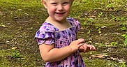 Maggie joined the competition — help win amazing prizes! child, girl, toddler, smiling, happy, portrait, outdoor, woodland, forest, garden, moss, grass, leaves, rocks, nature, purple_dress, floral_dress, standing, hands, daylight