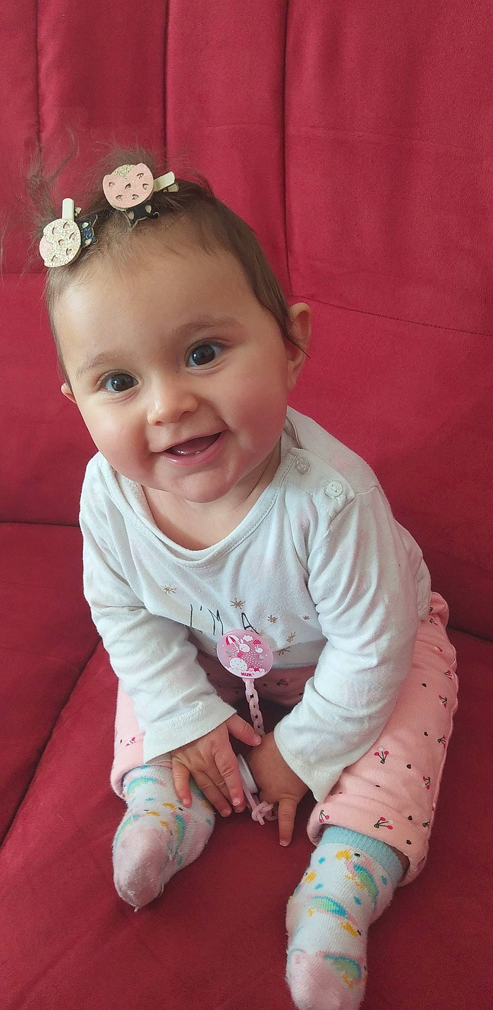 Tyhana participe au concours pour gagner de l'argent avec cette photo : arm, baby, cheek, child, ear, eye, finger, hair_accessory, head, iris, joy, lip, nose, person, pink, sitting, skin, smile, toddler