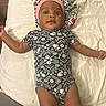 Essence joined the competition — help win amazing prizes! baby, infant, child, onesie, blanket, lying_down, face, headwear, bonnet, patterned_clothing, curious_expression, indoors, soft_texture, skin, arms_spread, closeup, person, newborn, cute, smile