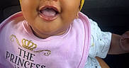 Essence is registered to the contest to win money with this photo: baby, child, smiling, headband, bow, bib, pink, yellow, happy, infant, clothing, cute, face, portrait, sitting, pattern, stars, clouds, person, indoor