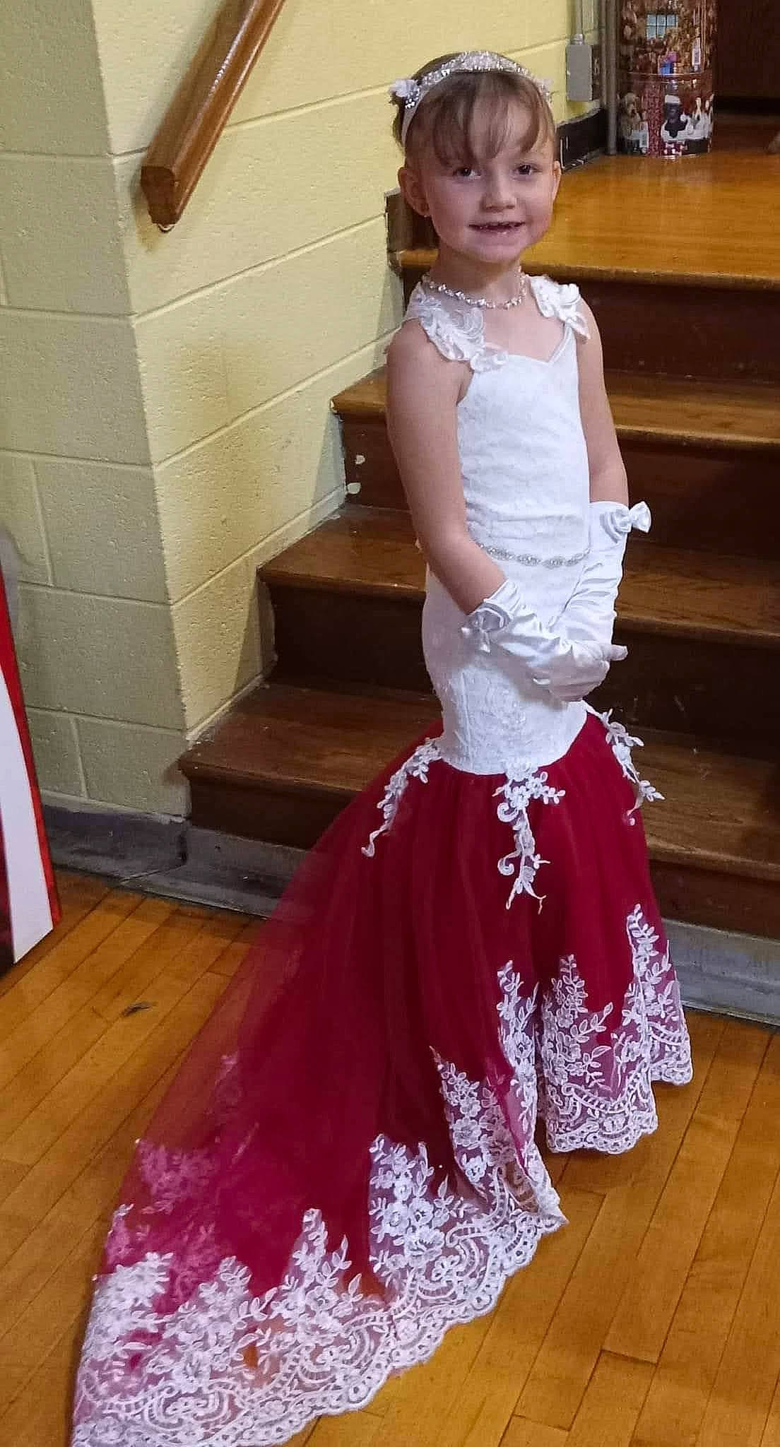 Alyssa is registered to the contest to win money with this photo: abdomen, child, embellishment, event, fashion_design, flooring, formal_wear, fun, gown, hairstyle, happy, hardwood, human_leg, joy, magenta, person, ruffle, shoulder, smile, thigh