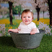 Esmée a rejoint le concours — aidez-le/la à gagner de superbes lots ! baby, background, blossom, child, cute, flower, garden, grass, green, happy, metal, nature, outdoor, portrait, sitting, small_bow, smile, spring, tub, white_clothing