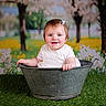 baby, background, blossom, child, cute, flower, garden, grass, green, happy, metal, nature, outdoor, portrait, sitting, small_bow, smile, spring, tub, white_clothing