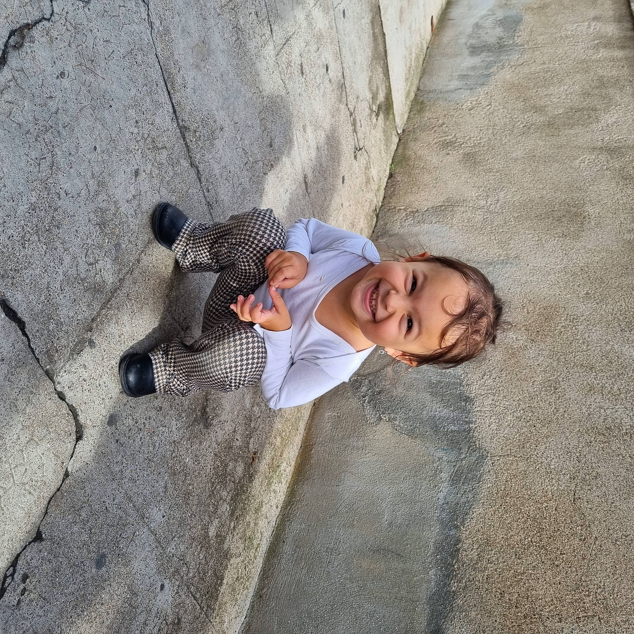 Yasmine participe au concours pour gagner de l'argent avec cette photo : adventure, asphalt, cobblestone, concrete, flooring, fun, grey, joy, landscape, outdoor_shoe, pedestrian, person, recreation, road_surface, rock, shadow, sidewalk, sitting, smile, toddler