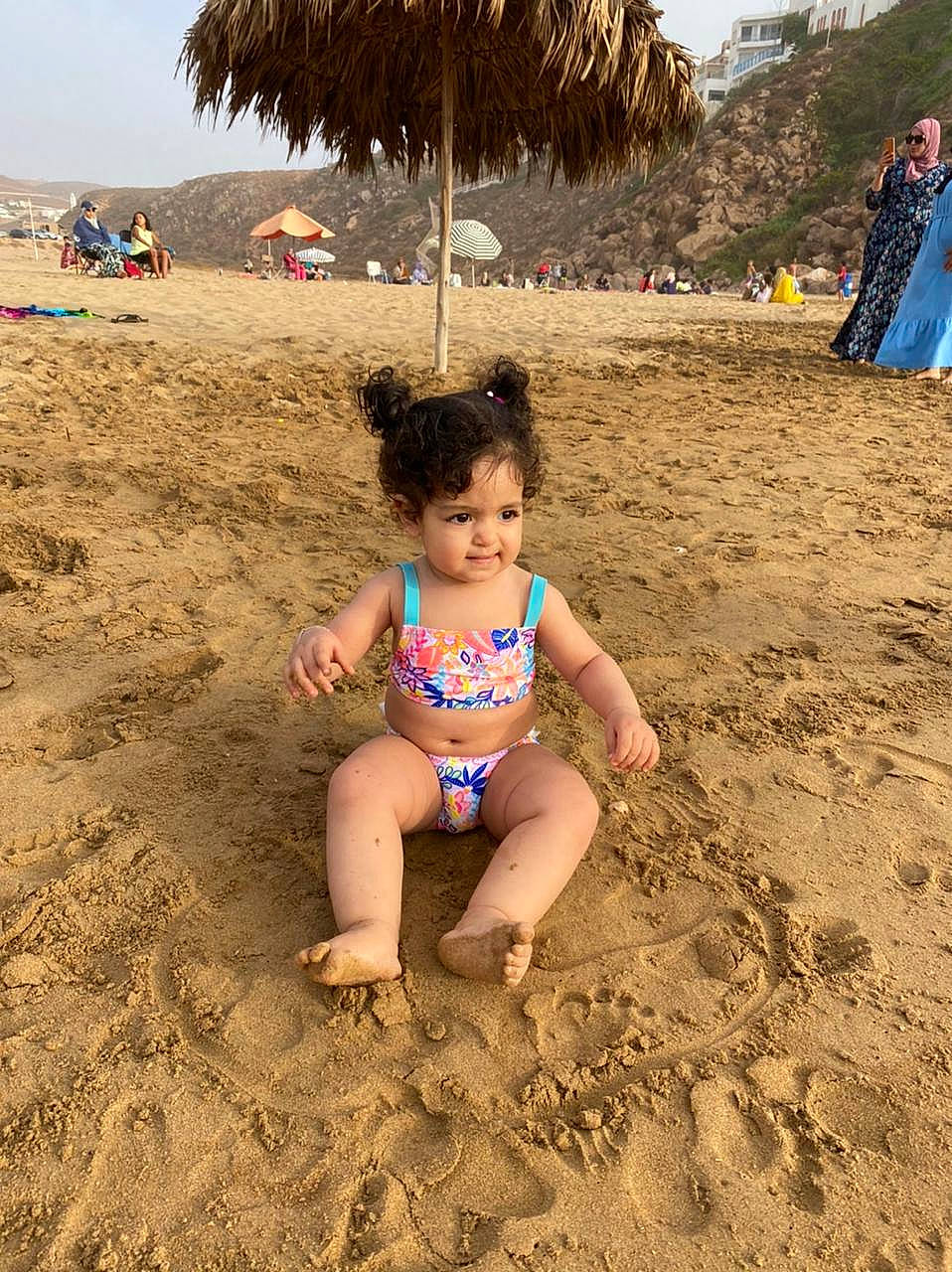 Jannat a rejoint le concours — aidez-le/la à gagner de superbes lots ! barefoot, beach, body_of_water, fun, human, human_leg, landscape, leisure, morning, people_in_nature, people_on_beach, person, shade, shore, sky, summer, thigh, toddler, travel, umbrella