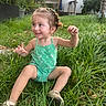 Aurora joined the competition — help win amazing prizes! braided_hair, child, daylight, flamingo_pattern, garden, girl, grass, green_clothing, hair_ties, happy, outdoor, plants, playful, portrait, romper, shoes, sitting, smiling, toddler, urban_garden