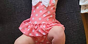 Deianira joined the competition — help win amazing prizes! arms_up, baby, child, chubby, cushion, cute, diapers, floor, footwear, home, indoor, infant, lying_down, person, pink, polka_dot, portrait, soft_lighting, swimsuit, white_bow