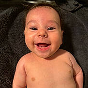 Jordan is registered to the contest to win money with this photo: baby, smiling, face, eyes, infant, skin, cheeks, mouth, tongue, expression, lying_down, blanket, happy, cute, child, portrait, human, adorable, head, closeup