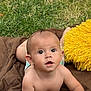 baby, blanket, child, curious, daylight, expression, face, grass, hand, head, infant, lying_down, nature, outdoor, person, plastic_bottle, skin, wide_eyes, yellow_pillow, young
