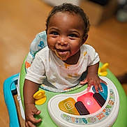 Kalino is registered to the contest to win money with this photo: baby, child, walker, toy, light, smile, happy, food_stains, indoor, floor, clothing, playtime, cute, infant, person, furniture, colorful, hand, face, young