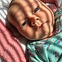 baby, infant, face, blue_eyes, blanket, striped_shadow, soft_texture, clothing, floral_pattern, cute, child, portrait, lying_down, skin, head, newborn, sleepy, indoors, closeup, warm_light