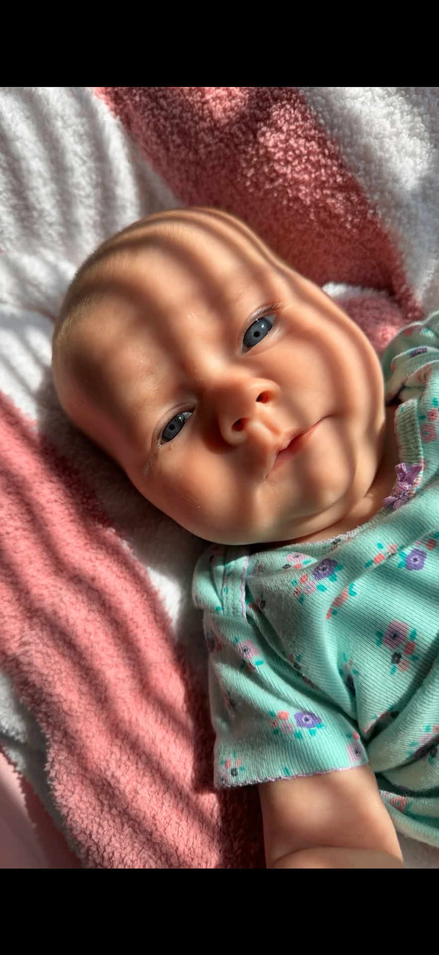 Vaeda joined the competition — help win amazing prizes! baby, infant, face, blue_eyes, blanket, striped_shadow, soft_texture, clothing, floral_pattern, cute, child, portrait, lying_down, skin, head, newborn, sleepy, indoors, closeup, warm_light