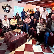 Yummi a rejoint le concours — aidez-le/la à gagner de superbes lots ! group, people, family, dog, living_room, couch, smiling, indoor, casual_clothing, glasses, table, wooden_beams, windows, photography, seated, standing, home_decor, carpet, mixed_ages, happy