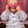 Charlie a rejoint le concours — aidez-le/la à gagner de superbes lots ! animal_print, baby, brown_pants, child, corduroy_pants, cute, fashion, fun, heart_shaped_sunglasses, indoor, person, playful, portrait, red_background, seated, smiling, sunglasses, sweater, toddler, wooden_background