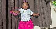 Jazlynn is registered to the contest to win money with this photo: bracelet, child, clothing, colorful, curtains, fashion, girl, houseplant, indoors, marble_floor, photography, pink_bow, pink_skirt, portrait, pouting, smiling, sneakers, standing, sunglasses, toddler