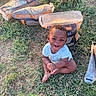 baby, child, infant, smiling, happy, sitting, outdoor, grass, garden, gardening, soil_bags, potting_mix, garden_tool, barefoot, portrait, face, curly_hair, blue_shirt, sunlight, lawn