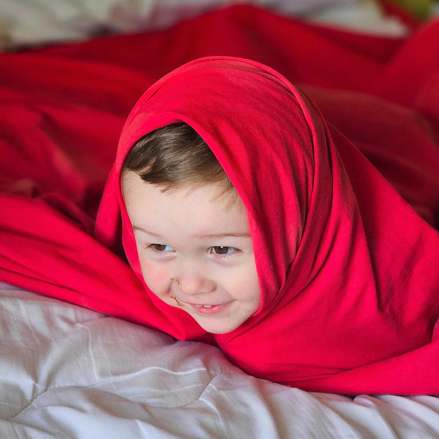 Reggie is registered to the contest to win money with this photo: baby, bed, bedroom, blanket, clothing, couch, face, furniture, happy, head, hood, hoodie, indoors, knitwear, person, photography, portrait, smile, sweater, sweatshirt