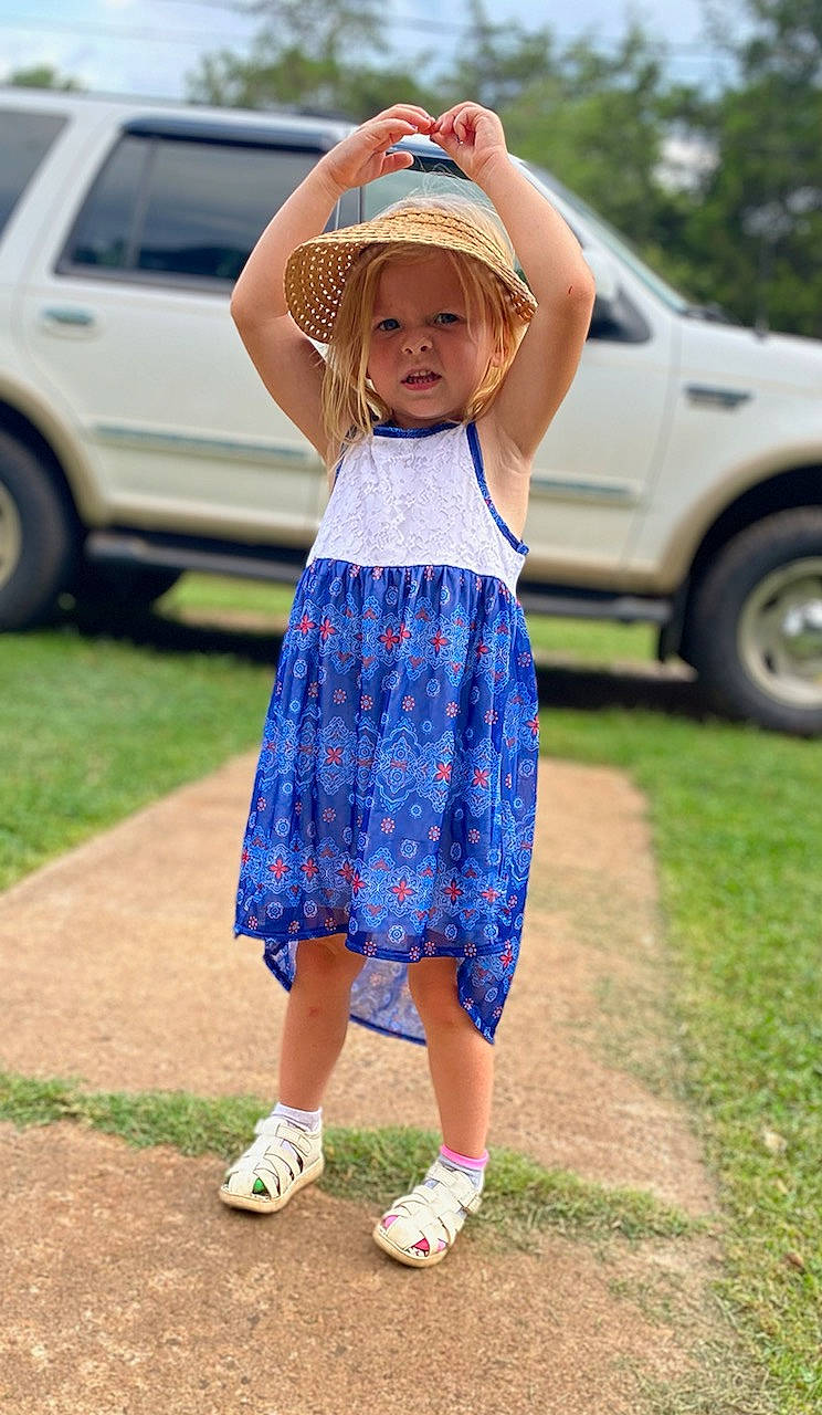 Lillyana is registered to the contest to win money with this photo: automotive_exterior, automotive_tire, car, dress, footwear, grass, hair, happy, hat, headwear, land_vehicle, long_hair, person, plant, summer, t_shirt, tire, toddler, trunk, vehicle_door