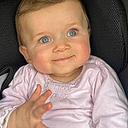 Emy a rejoint le concours — aidez-le/la à gagner de superbes lots ! baby, child, blue_eyes, pink_clothing, smile, hand, portrait, closeup, seated, rosy_cheeks, infant, cute, curious, soft_light, indoor, texture, face, young_child, expression, happy