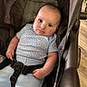 baby, blue_clothing, caucasian_baby, cheeks, child, clothing, curious, expression, eyes, face, floor, hands, head, indoor, infant, person, polka_dot, seatbelt, sitting, stroller
