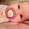 Ella is registered to the contest to win money with this photo: baby, pacifier, close_up, infant, lying_down, pink, blanket, cute, face, expression, child, soft_lighting, cozy, clothing, resting, indoors, portrait, young_child, human, skin