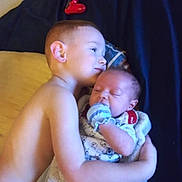 Kade joined the competition — help win amazing prizes! child, baby, hug, bed, blanket, shirtless, sleeping, toy, controller, blue, red, cozy, comfort, family, brothers, love, indoor, portrait, cuddle, toddler