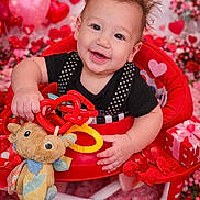 Atreus joined the competition — help win amazing prizes! baby, black_shirt, child, cute, decorations, flowers, gift, happy, hearts, indoor, person, pink, plush_toy, polka_dot, portrait, red, smiling, toy, valentines_day, walker