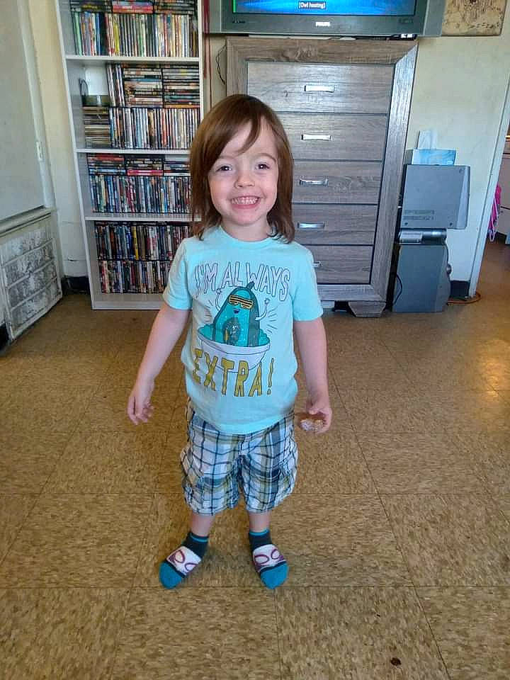 River is registered to the contest to win money with this photo: baby_toddler_clothing, bookcase, cabinetry, child, drawer, floor, flooring, hair, human_body, joint, joy, leg, person, shelf, shorts, sleeve, smile, standing, t_shirt, thigh