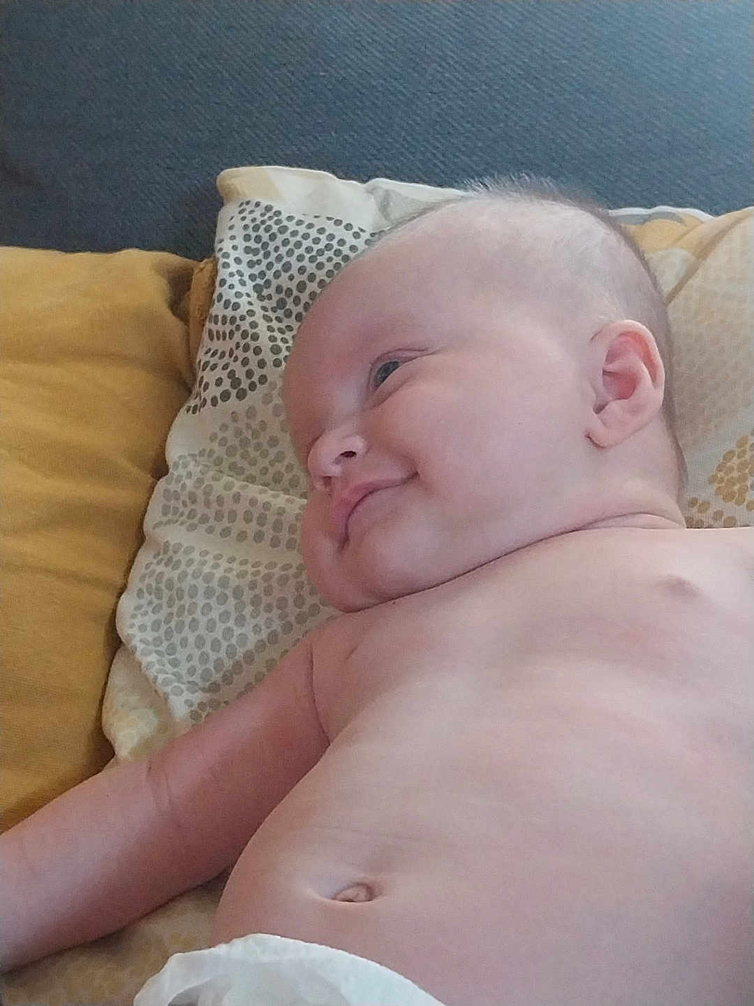 Chloé participe au concours pour gagner de l'argent avec cette photo : baby, infant, smile, skin, face, ear, arm, belly, pillow, cushion, fabric, pattern, diaper, lying_down, child, cute, indoors, relaxed, happy, young