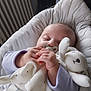 Chloé participe au concours pour gagner de l'argent avec cette photo : baby, infant, pacifier, plush_toy, blanket, cushion, sleepy, hand, soft_toy, child, cute, comfort, indoors, portrait, relaxed, wearing_clothes, small_hands, resting, peaceful, cozy