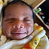 Taylen is registered to the contest to win money with this photo: baby, newborn, smile, face, wrapped, blanket, infant, cute, sleeping, close_up, soft, peaceful, child, portrait, warm, cozy, happy, skin, head, young