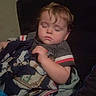 Josh is registered to the contest to win money with this photo: child, toddler, sleeping, nap, portrait, face, closed_eyes, brown_hair, indoor, blanket, couch, seated, resting, casual_clothing, striped_shirt, cozy, home, dim_lighting, photography, cute
