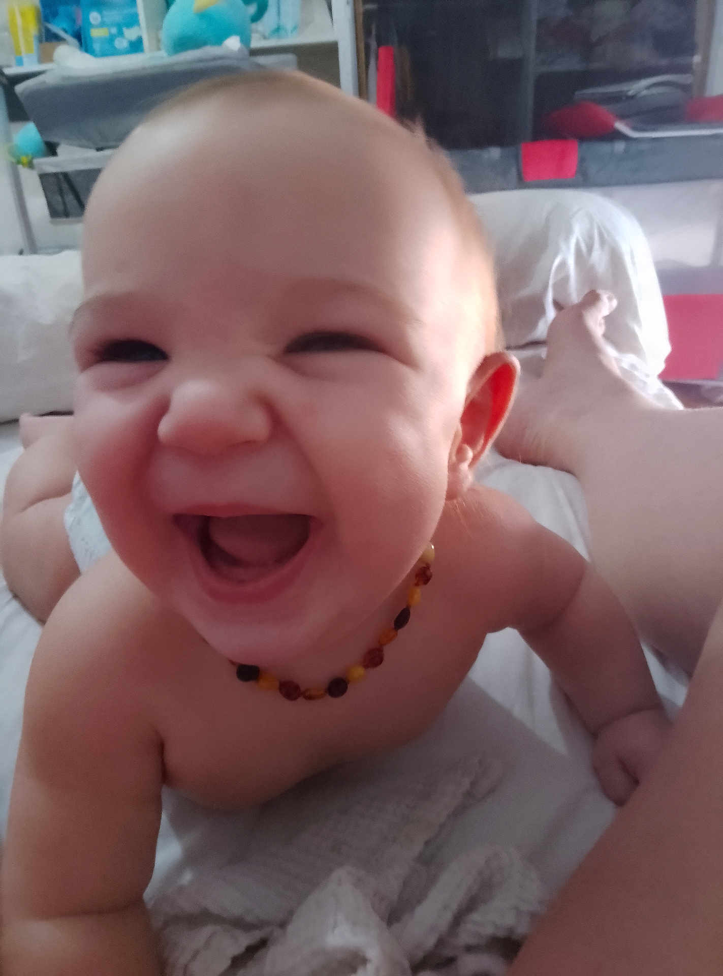 Valentin a rejoint le concours — aidez-le/la à gagner de superbes lots ! baby, smiling, laughing, closeup, bead_necklace, bed, indoor, person, skin, happy, child, infant, bare_chest, blanket, legs, foot, home, candid, cute, joy
