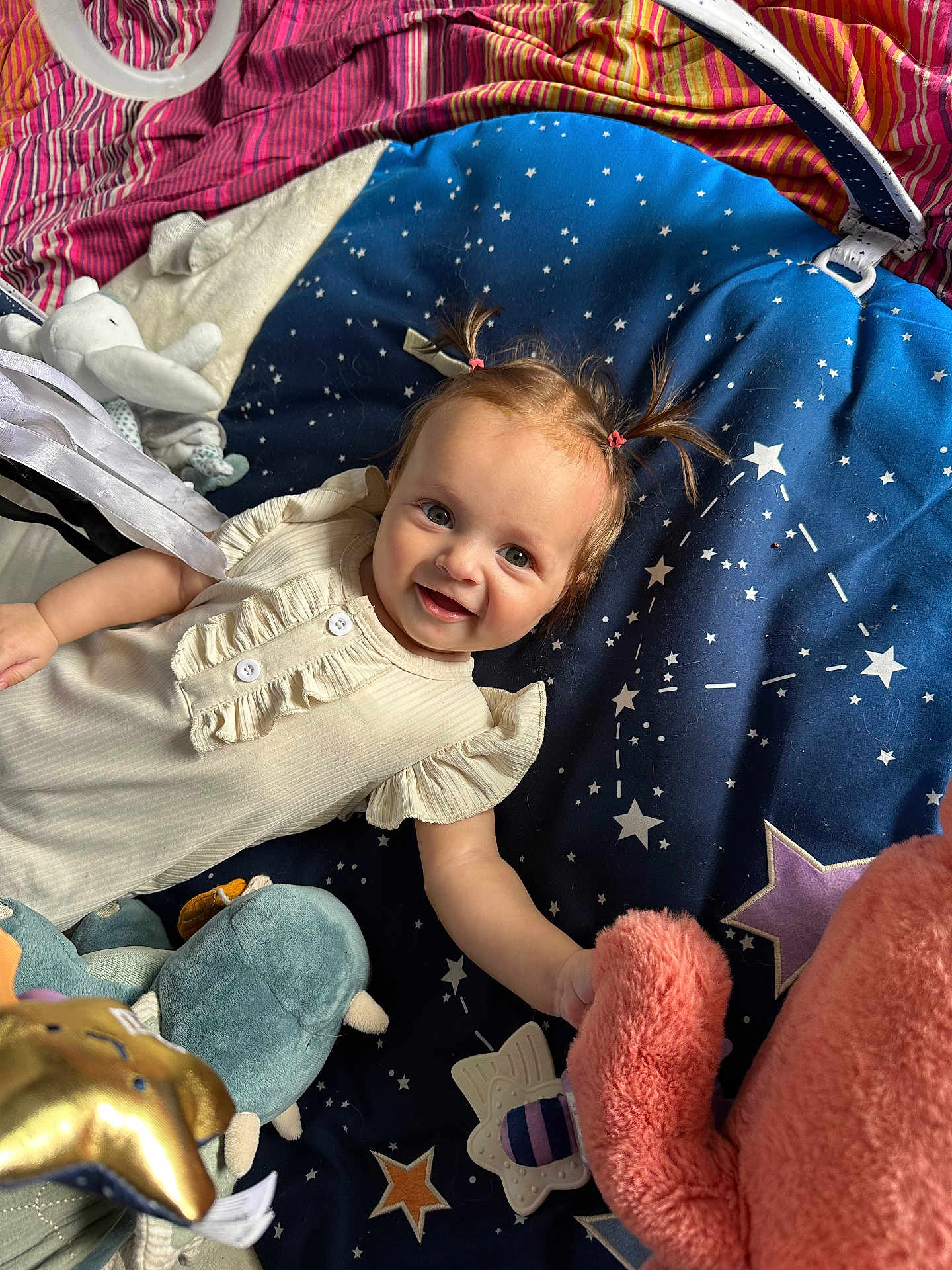 Lisa a rejoint le concours — aidez-le/la à gagner de superbes lots ! baby, child, pigtails, smiling, plush_toy, stuffed_animal, blanket, stars, blue_blanket, pink_toy, golden_star, white_clothing, cute, happy, lying_down, indoors, playtime, soft_toys, infant, cozy