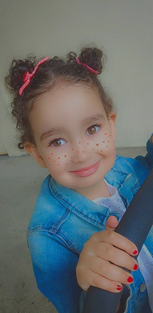 Zora participe au concours pour gagner de l'argent avec cette photo : baby_toddler_clothing, cheek, child, chin, denim, ear, eye, eyebrow, fashion_accessory, finger, forehead, hair_accessory, hairstyle, hand, headgear, iris, joy, lip, organ, person